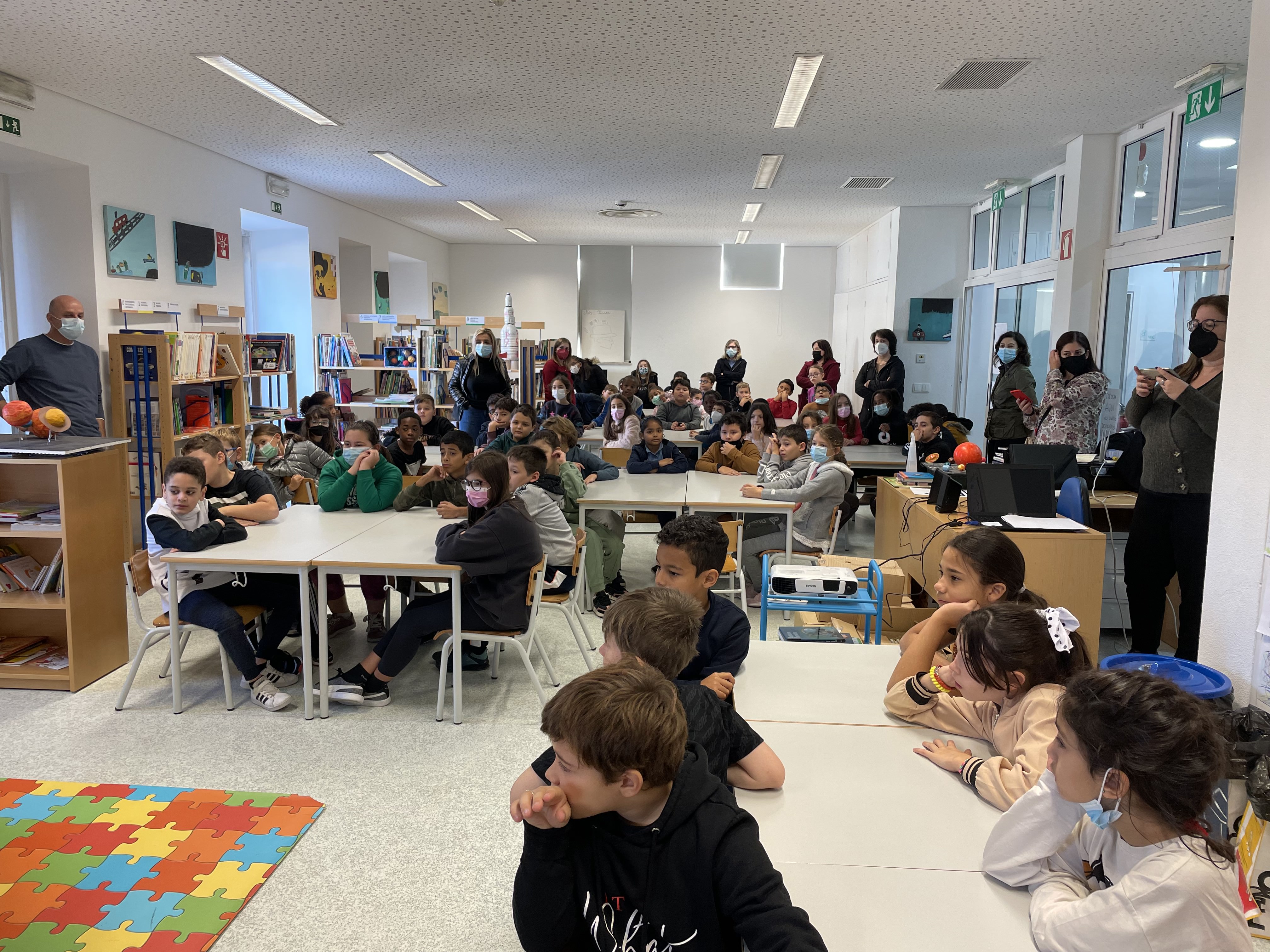 foto de crianças sentadas em mesas numa escola